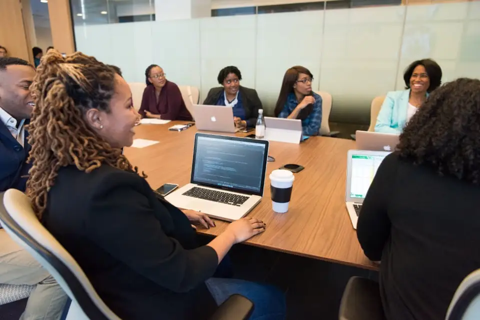 A team around a conference table working on laptops